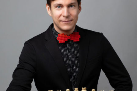 ROCO Guest Composer Maxime Goulet posing with a chess board ahead of the premiere of Checkmate